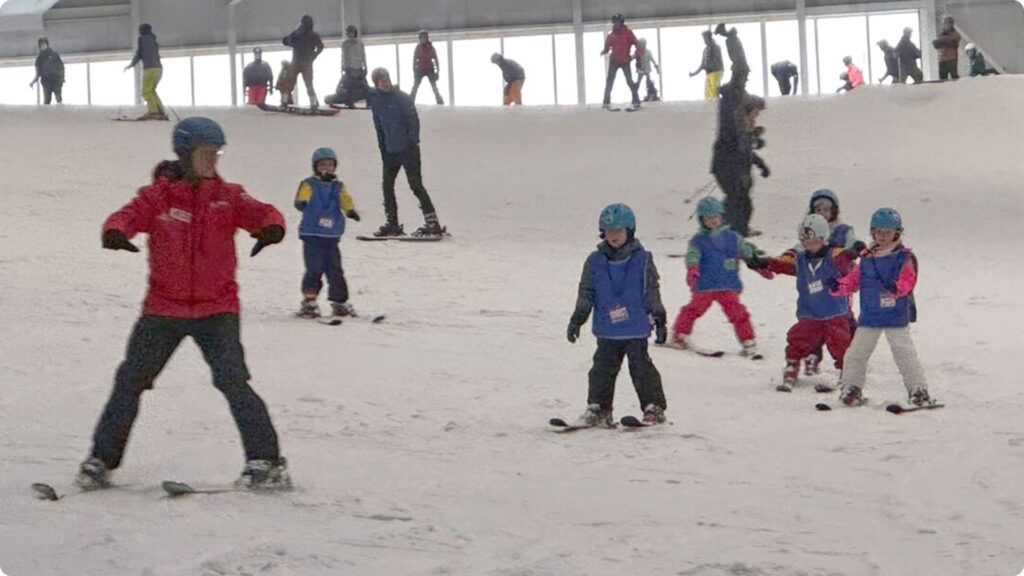 monitor geeft groepsles tijdens familieskiën